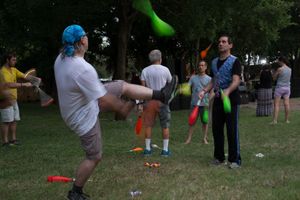 Two jugglers juggle bowling pins