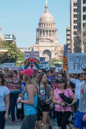 Protesters march with the Texas Capital building in the background
