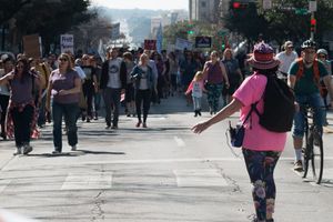 Woman on the street stands in front of an oncomoing crowd of people