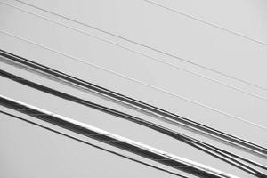 Telephone wires against a clear blue sky.