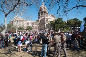 A crowd with the Texas Capital building in the background.